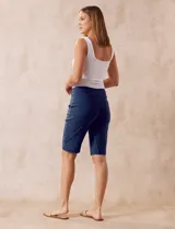 Bermuda azul marino en gabardina elastizada con pretina ancha elastizada, bolsillos delanteros simulados y bolsillos traseros aplicados.