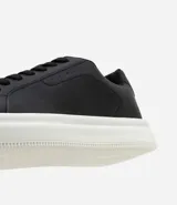 Championes blancos de cuero sintético con cordones y suela gruesa.