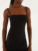 Vestido largo negro con tirantes finos y corte recto.