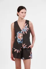 Short de tiro medio con cintura elástica y bolsillos laterales. Presenta un estampado floral grande en tonos azules, rosados y terracota sobre fondo negro.