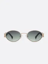 Lentes de sol ovalados con marco dorado y lentes con degradado de negro a verde.