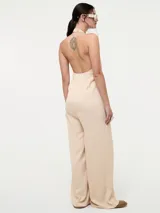 Mono de corte ancho, con escote en V y tirantes finos, confeccionado en mezcla de viscosa y rayon.
