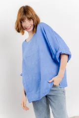 Blusa color beige confeccionada en lino, de corte holgado, mangas 3/4 y cuello redondo.