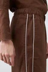 Pantalón de lino color chocolate, de corte palazzo, con cintura elastizada y vivo blanco en los laterales.