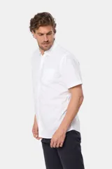 Camisa de hombre color azul marino, de manga corta, con cuello clásico, cierre frontal con botones y bolsillo en el pecho.