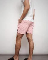 Short de baño rosado con estampado de hojas y flores en el mismo tono, cintura elástica con cordón ajustable negro y bolsillo trasero con etiqueta de marca.