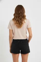 Remera color rosa pálido de algodón con cuello en V y estampado de un corazón formado por flores y hojas en tonos borgoña.