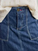 Falda midi color beige, de corte evasé, con bolsillos delanteros y ruedo desflecado.