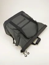 Bolso tipo duffel verde militar con base y detalles en negro. Tiene doble asa de mano y correa de hombro ajustable y extraíble. Cuenta con dos bolsillos frontales con cierre y logo de la marca en la parte inferior.