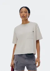 Remera color beige de corte recto, con cuello redondo y bolsillo en el pecho.