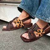 Sandalias bajas de cuero color marrón con detalle de nudo y estampado animal print.