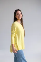 Sweater amarillo de corte recto con cuello redondo. La parte delantera es más corta que la trasera y tiene aberturas en la espalda.
