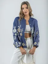 Camisa de jean azul con bordado de flores en tonos champagne y cobre, cuello mao y corte amplio.