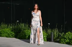 Vestido largo de fiesta con estampado floral, escote drapeado y abertura lateral en la falda.