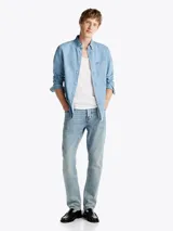 Camisa de denim celeste de Tommy Hilfiger de corte regular, con cuello abotonado, manga larga con puños abotonados, bolsillo de parche en el pecho y logo bordado en el bolsillo.
