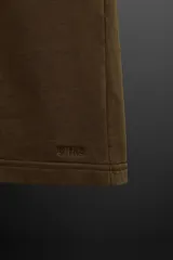 Bermuda jogger negra confeccionada en tejido de algodón con interior de rizo, cintura elástica ajustable con cordón y bolsillos laterales.