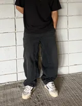 Pantalón de jean negro de corte ancho con costuras reforzadas en las rodillas.