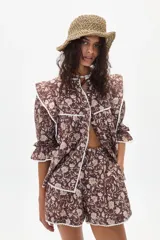 Short de tiro alto confeccionado en lino con estampado floral en tonos tierra y terminación en borde con cinta de encaje blanca.