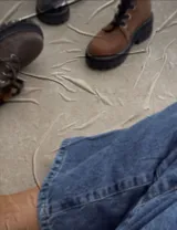 Borcego marrón de cuero con cordones, caña baja y suela track.