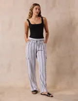 Pantalón cargo de lino color blanco, marca Marissa Olivia. Tiene pretina ancha elastizada con lazo de ajuste, bolsillos inclinados delanteros y bolsillos laterales con botón.