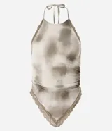 Top halter de tela satinada, color beige con efecto tie-dye/manchas en tonos marrones. Presenta detalles de encaje en el escote y el bajo. El diseño es ajustado al cuerpo.