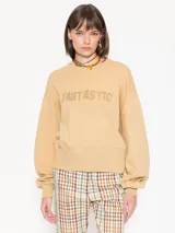 Buzo color beige de punto, con calce amplio y mangas largas. Estampa frontal con la palabra "Fantastic" con strass y logo bordado en la espalda.