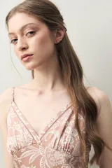 Camisón de silueta femenina y liviana, color rosado con estampado floral en blanco. Presenta escote en V con detalle de encaje delicado y breteles finos regulables. El corte es evasé para una caída fluida.