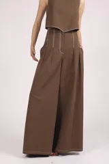 Conjunto color crema compuesto por top corto sin mangas y pantalón palazzo de tiro alto con pinzas y pespuntes a contraste.