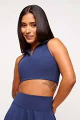 Top deportivo azul marino con cuello polo y cierre parcial con cremallera.