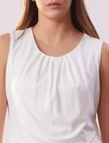 Blusa sin mangas color amarillo, con cuello redondo con frunces delanteros y abertura con botón en la espalda.