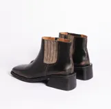 Bota corta negra de cuero con elástico lateral, caña de 12 cm y taco de madera de 4 cm.
