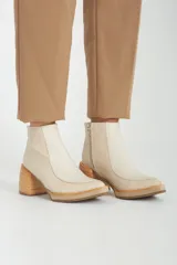 Botas de cuero blancas con tacón de madera y cierre lateral.