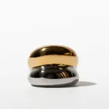 Anillo de acero enchapado, con diseño abultado bicolor: dorado en la parte superior y plateado en la inferior.