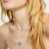 Colgante de doble cadena corta plateada con dije de mantarraya.