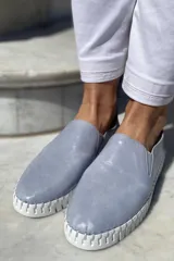 Slippers de cuero celeste con elásticos laterales y suela de goma blanca.