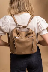 Cartera mochila color marrón de símil cuero suave con múltiples bolsillos con cierre, división al medio y correa ajustable de doble manija para llevar al hombro y como mochila.