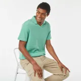 Remera verde de punto de piqué con cuello en V y mangas cortas.