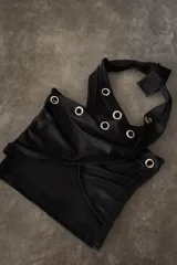 Top negro con diseño cruzado en el frente, estilo halter y con detalles de tachas doradas.