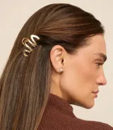 Set de dos pinzas para el pelo onduladas, una dorada y otra plateada, hechas de metal.