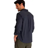 Camisa de popelina verde con cuello abotonado, cierre frontal con botones, bolsillo de parche en el pecho izquierdo, mangas largas con trabillas para enrollar y dobladillo camisero.