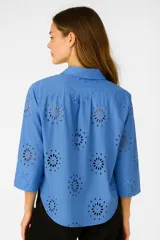 Camisa celeste con broderie, de corte holgado, con botones y cuello camisero, y mangas 3/4.