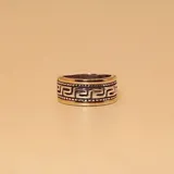 Anillo ancho de plata y oro con diseño geométrico de grecas.