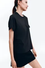 Remera negra de algodón, corte amplio, con cuello redondo y mangas cortas.