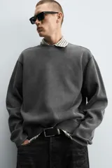 Sudadera gris oscuro de corte relaxed fit, con cuello redondo, manga larga y efecto lavado.