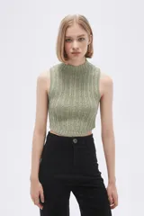 Chaleco verde pálido de punto con cuello alto y diseño trenzado.