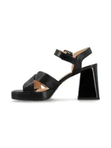 Sandalias de cuero color canela con plataforma y tacón ancho. Tiras cruzadas en el empeine y pulsera ajustable con hebilla en el tobillo.