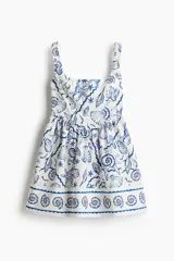 Vestido corto de algodón con estampado de motivos marinos en azul, con costuras estilo corset adelante y atrás. Modelo de cuerpo entallado con breteles anchos, escote cuadrado y cierre oculto con corchete en la espalda. Costura fruncida en la cintura y pollera con vuelo. Cuerpo forrado.