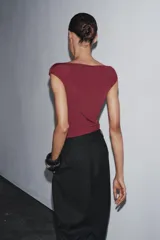 Body negro de poliamida con cuello barco, manga corta y cierre con broches a presión en la parte inferior.