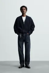 Cárdigan azul marino de punto con cremallera frontal, cuello en pico y manga larga.