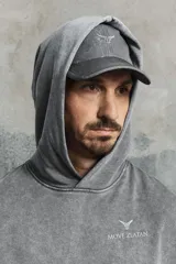 Gorra gris con estampado jaspeado, logo plateado en el frente, ojales bordados y cordón elástico ajustable en la parte trasera.